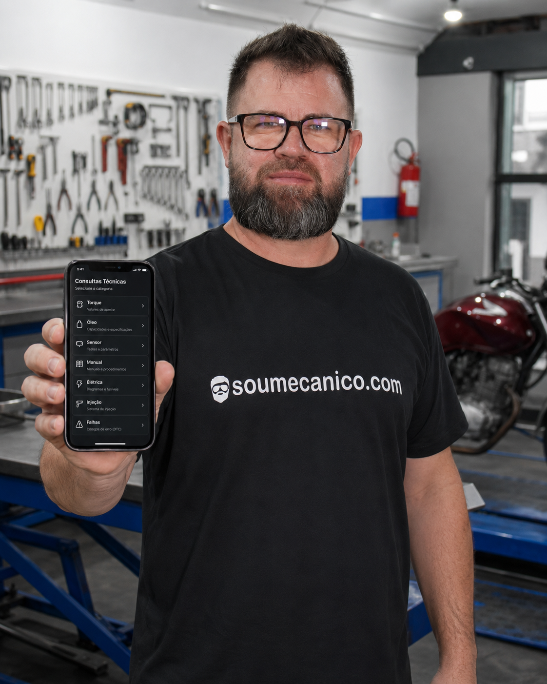 Airton Cardoso na oficina segurando o celular com a ferramenta de consulta técnica